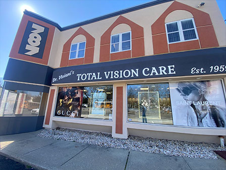 The image shows a storefront with the sign  Total Vision Care  and an advertisement for eyeglasses.