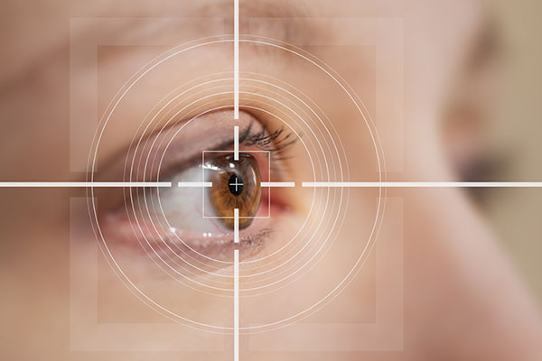 The image depicts a close-up view of an eye with a magnified, overlaid reticle pointing directly at it.