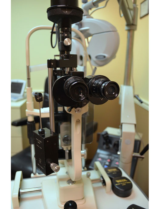 The image shows an optical device, specifically a slit lamp, which is commonly used in optometry and ophthalmology settings for examining the eyes.