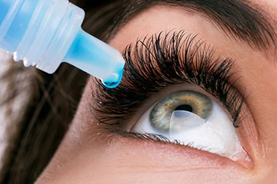 A person s eye with an eyelash extension applicator being used to apply lashes.